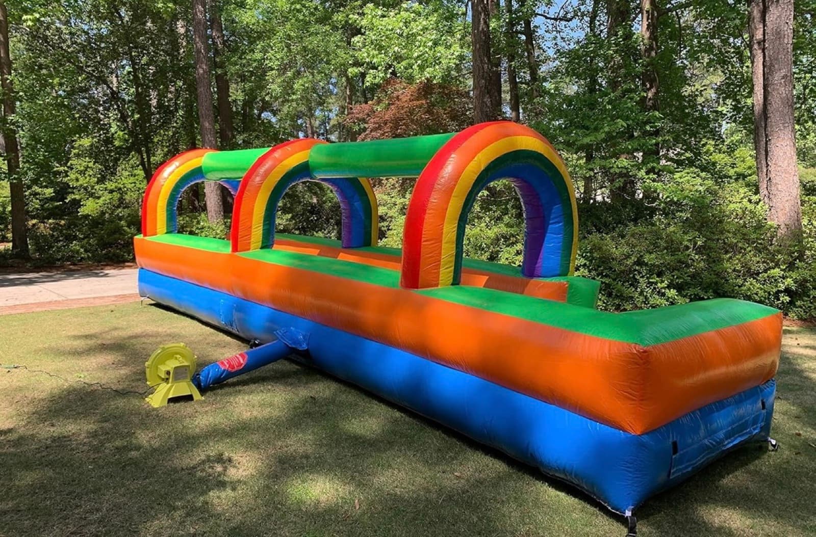 Rainbow colored inflatable slip and slide set up on grass